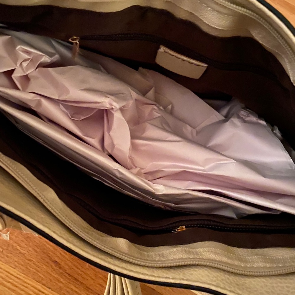 Beige handbag with gold buckle accent handbag